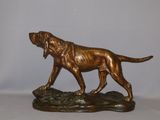 bronze statue of a dog on a rock on a white background
