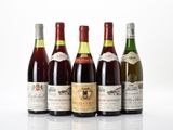 six bouteilles de vin sont alignées sur une surface blanche