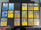 a person holding a box of pokemon cards on a table