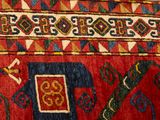 a close up of a red and blue rug with an elephant on it