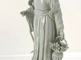 a statue of a woman holding a basket of flowers