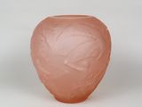 un vase rose orné d'un motif sur un fond blanc