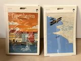two posters of a plane and a map on a table