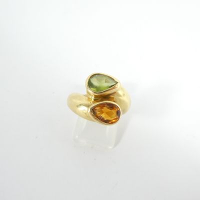 un gros plan d'une bague en or sertie de deux pierres de couleurs différentes