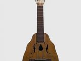 une vieille guitare en bois posée sur une surface blanche