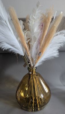 a gold vase with some white feathers in it