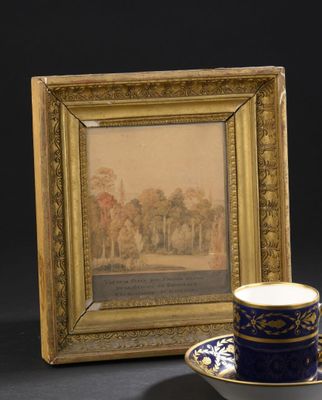 une tasse et une soucoupe posées à côté d'un cadre photo