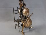 a statue of a man sitting on a chair with a guitar