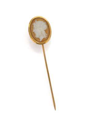 a close up of a gold plated broochle with a woman ' s face