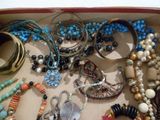 une boîte remplie de bracelets et de colliers de toutes sortes