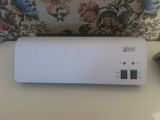 a white air purifier sitting on a table next to a pillow
