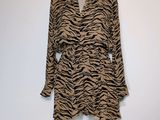 une robe à imprimé zébré marron et noir posée sur un pied de mannequin