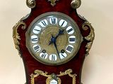 une petite horloge surmontée d'un oiseau