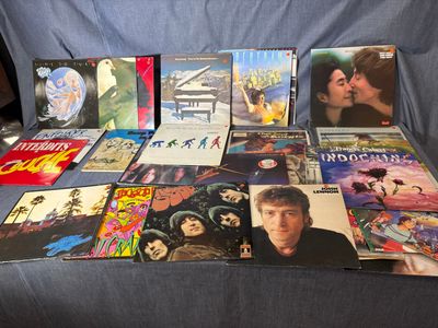 plein de disques vinyles posés sur un canapé bleu