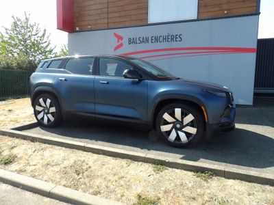 un SUV bleu garé devant un immeuble