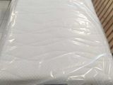 a mattress that is wrapped in plastic and sitting on the floor