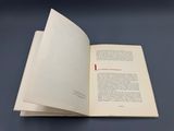 un livre ouvert posé sur une table, à côté d'une table bleue