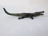 a toy alligator that is laying down on a white surface