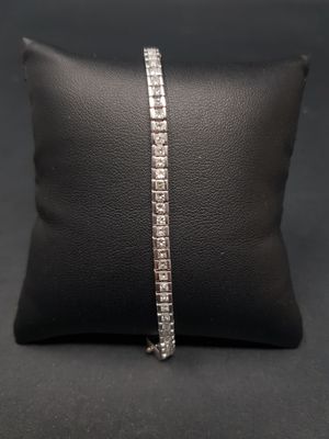 un bracelet « tennis » en diamants posé sur un coussin