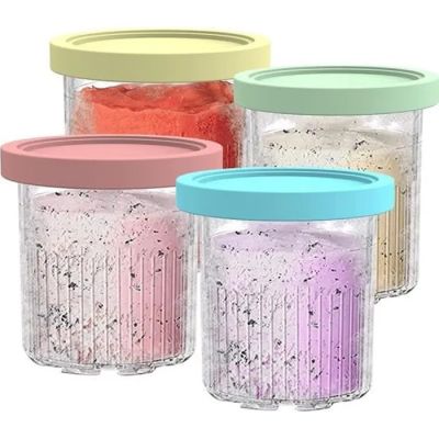 quatre bocaux contenant du sucre de différentes couleurs, posés sur un fond blanc