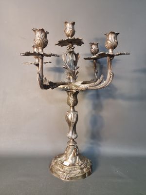 un candélabre en argent orné d'oiseaux, posé sur une table