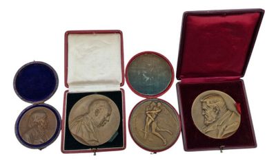 four medals in a red case sitting on top of a white surface