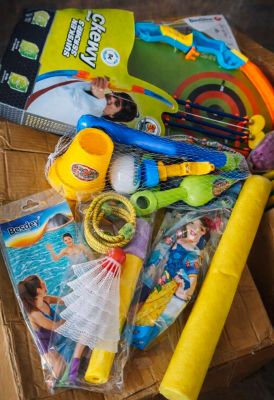 une boîte remplie de jouets et un livre posés sur une table