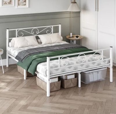 un lit blanc recouvert d'une couverture verte, dans une chambre
