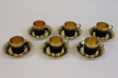 six tasses et soucoupes à bord doré sur fond blanc