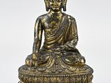 a bronze statue of a person sitting on a lotus
