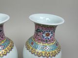 two white vases with colorful designs on them