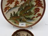 two plates with a painting on them sitting next to each other
