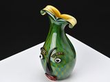 a green and yellow vase with a fish face on it