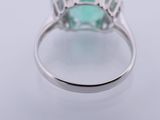 a close up of a ring with an emerald stone in it