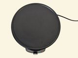 a black plate on a white surface with a black cord