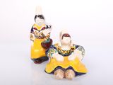 two figurines of a woman and a man sitting next to each other