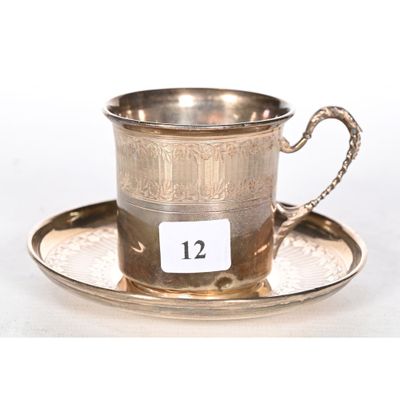 an antique silver cup and saucer on a saucer with a number 12 on it