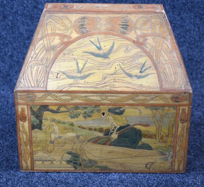 a wooden box with a painting on it on a blue carpet