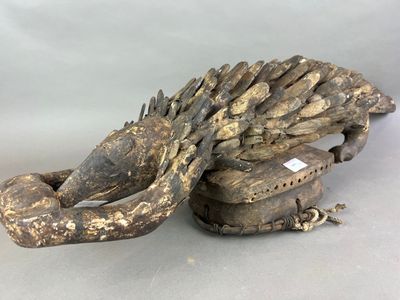 une photo d'une sculpture en bois représentant un lézard avec des épines sur le dos