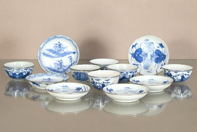 several blue and white plates and bowls sitting on a glass table