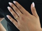 someone is wearing a gold ring with a diamond on it