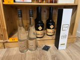 trois bouteilles de vin sur une étagère à côté d'une télécommande