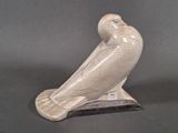 statue of a bird on a stand on a gray background