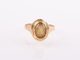 a close up of a gold ring with a brown stone in it