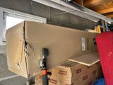 a pile of boxes and a red suitcase in a garage