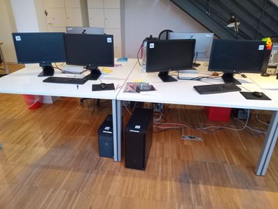 trois écrans d'ordinateur posés sur le bureau de ce bureau