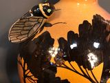 a vase with a dragonfly on it on a table