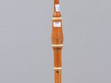 a small wooden instrument that is on a clear stand