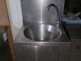 a stainless steel sink with a faucet in the corner of the room