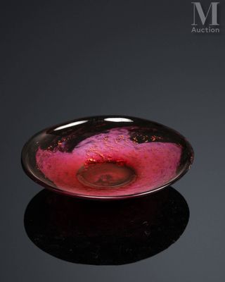 a glass bowl with a pink substance in it on a black surface